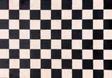 Close-up of a checkered pattern Floor Mat with black and cream squares