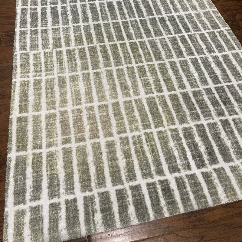 Textured green and beige checkered mat on a wooden floor